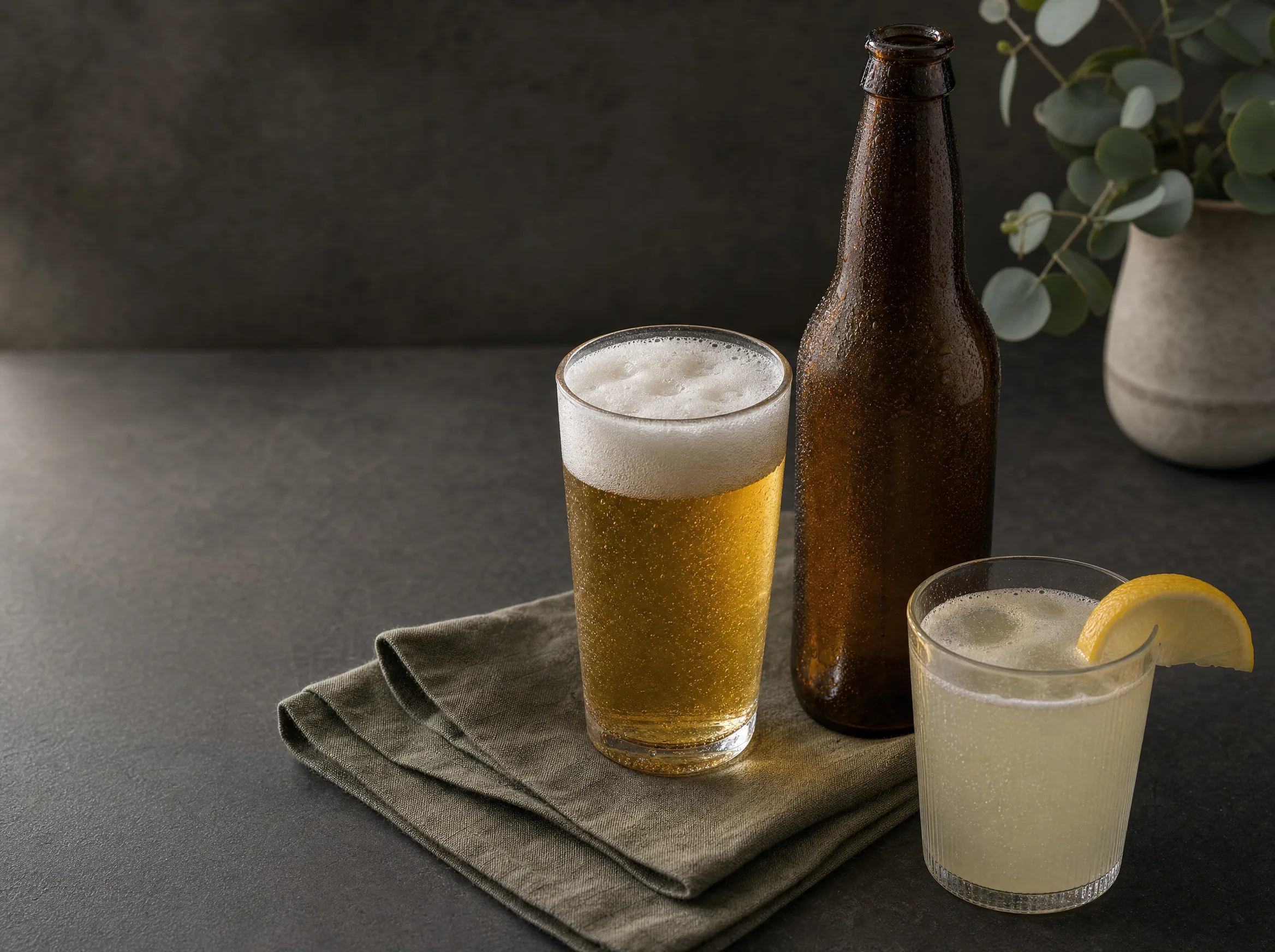Eine neutrale braune Bierflasche mit einem hellen Bier und einem Radler mit Zitrone.